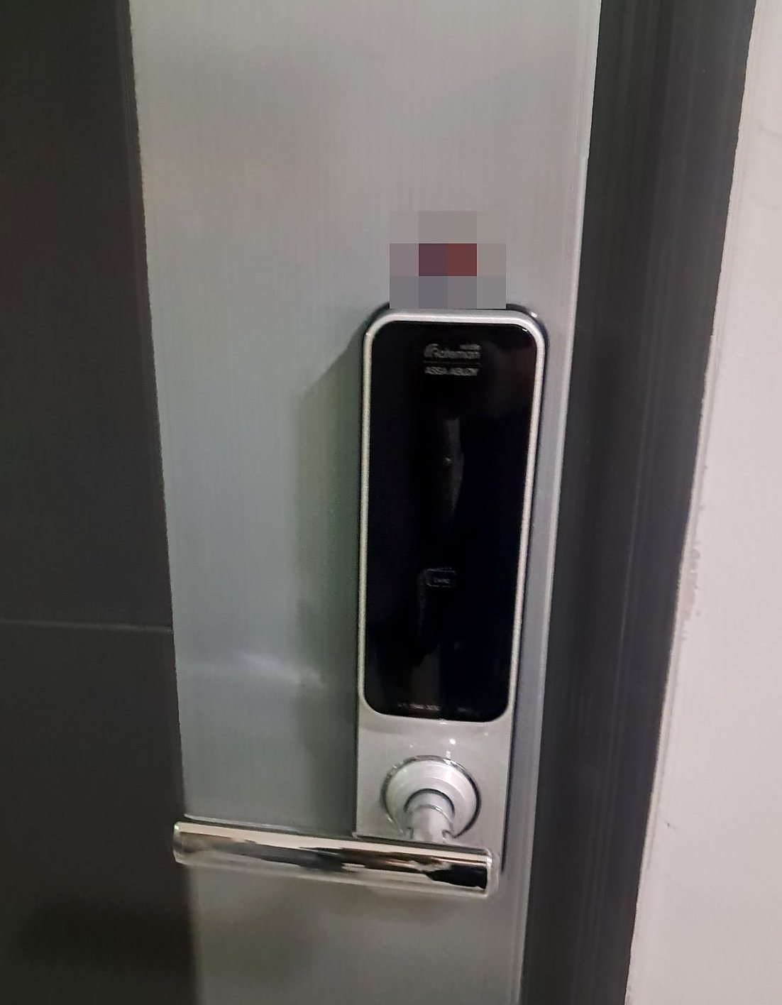 관악구 신원동 출장 — 짙은 문틀 안쪽 연회색 문에 단 가늘고 긴 도어락, 검은 앞면과 은색 레버 손잡이